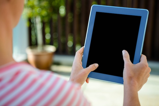 mani femminili, scorrendo su un tablet in un giardino