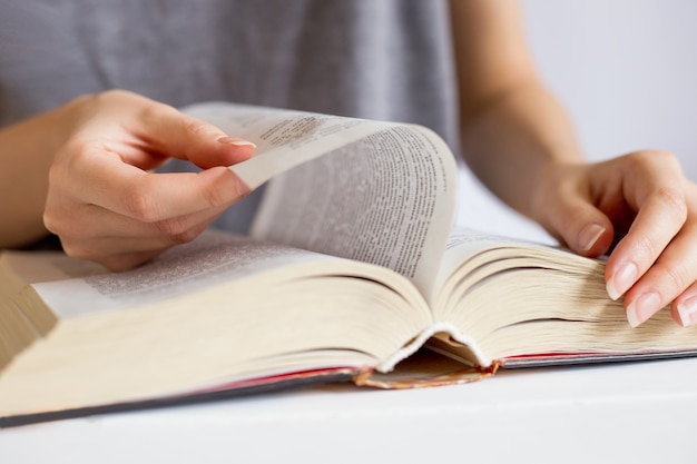 Mani femminili sfogliando pagine di libri. concetto di lettura