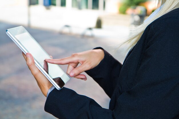 Mani femminili toccando la tavoletta digitale