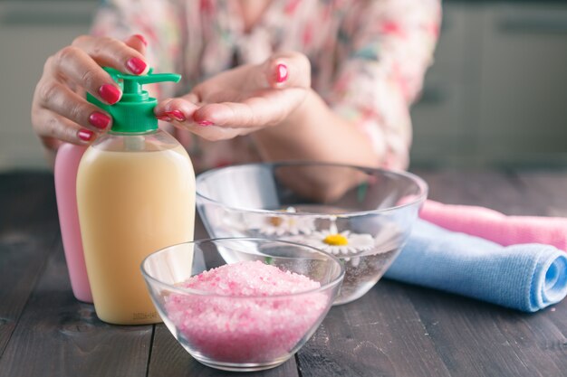 Mani femminili usando sapone liquido