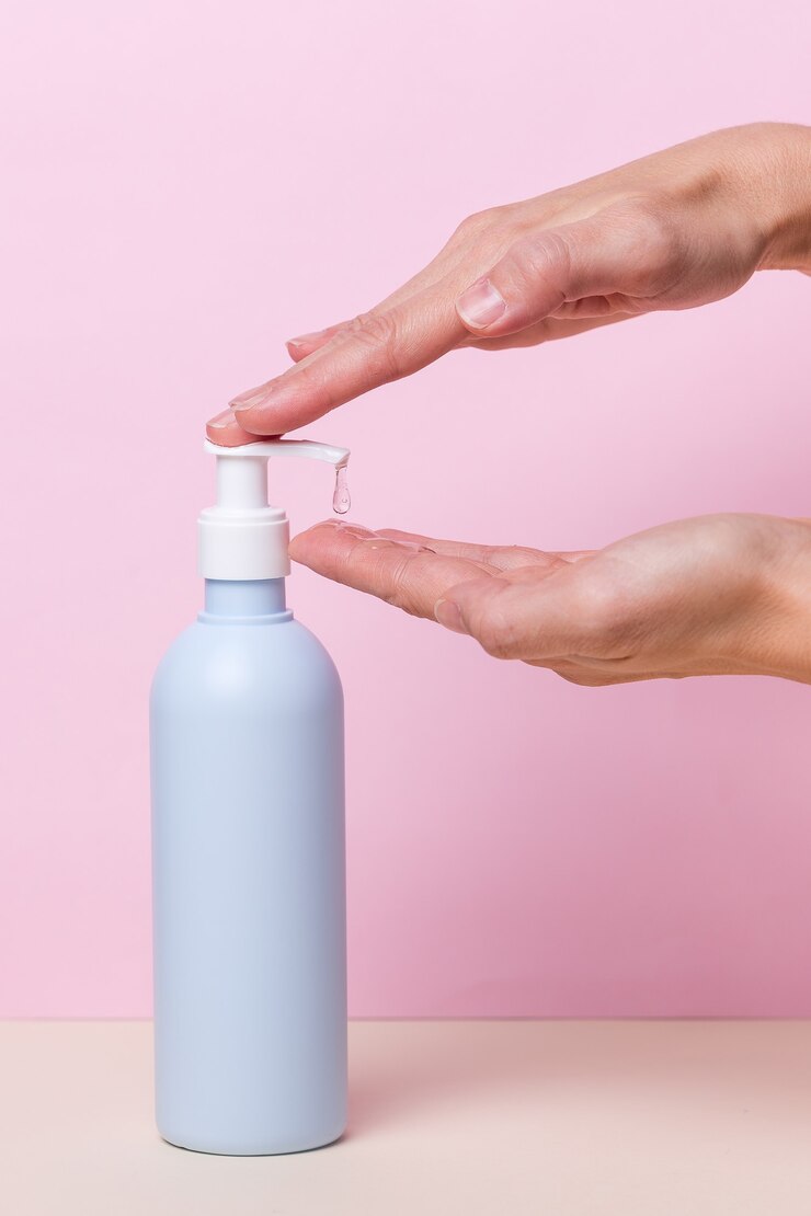 Mani femminili utilizzando alcol gel disinfettante bottiglia dispenser