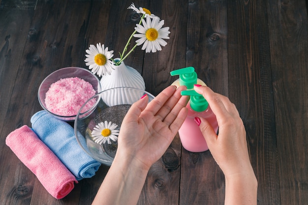 Mani femminili utilizzando dispenser con sapone liquido