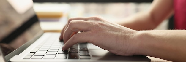 Mani giovani di sesso femminile stanno digitando su una tastiera portatile primo piano impiegato di ufficio business online