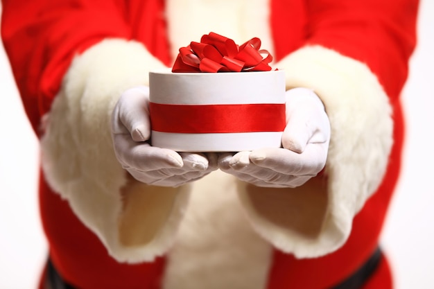 Mani guantate di Babbo Natale che tengono giftbox
