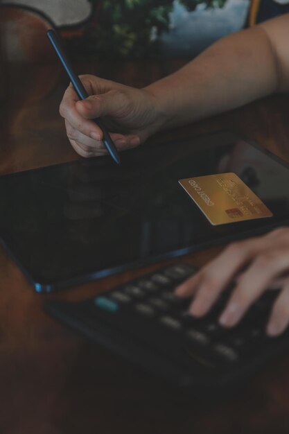 Mani in possesso di carta di credito e utilizzando laptop Acquisti online