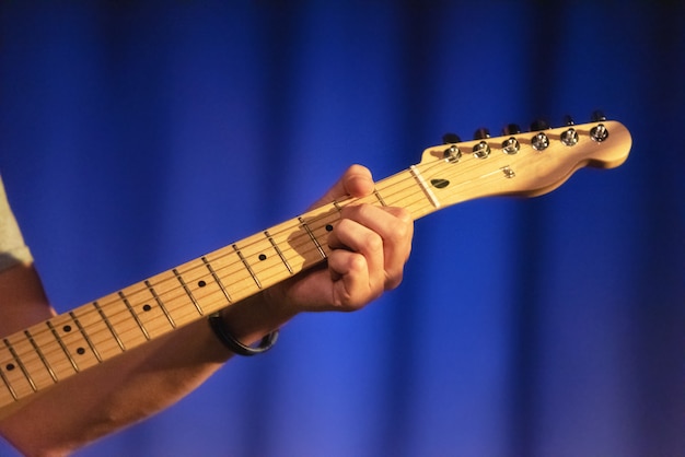 Mani maschii che giocano sulla chitarra elettrica, fine in su.