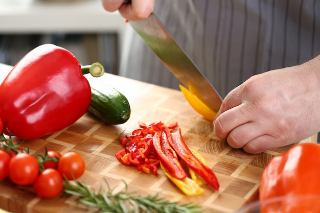 Mani maschii che tagliano Chili Salad Ingredient giallo