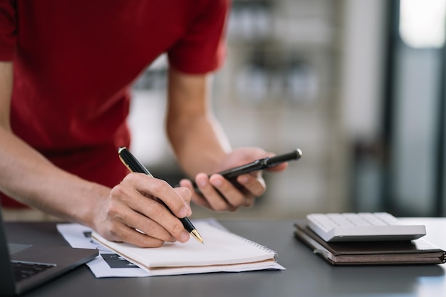 Mani maschili che prendono appunti su una scrittura creativa del blocco note scritto a mano