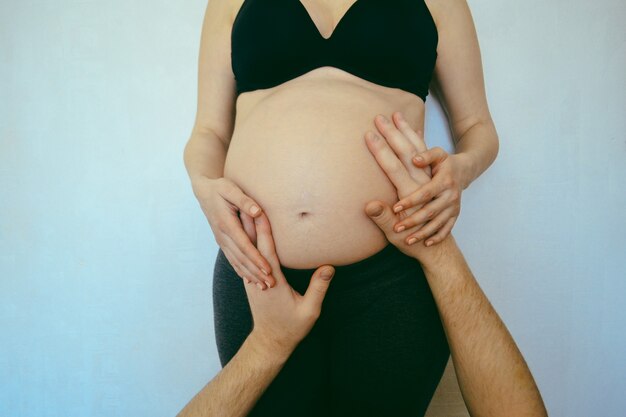 Mani maschili sulla pancia di una donna incinta Concetto gravidanza familiare family