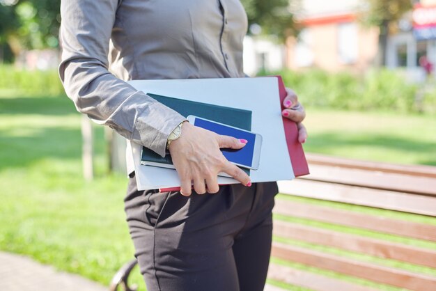 Mani ravvicinate di donna d'affari con taccuino, documenti, smartphone. Concetto di uomini d'affari