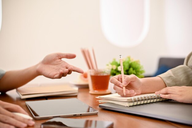 Mani ritagliate e focalizzate Due colleghi amici che lavorano e fanno brainstorming insieme