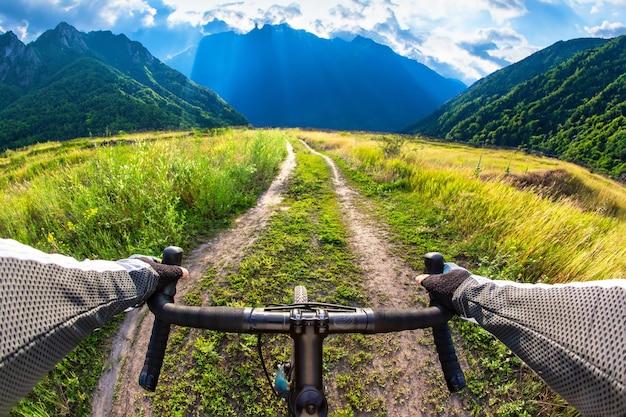 mani sul manubrio di una bicicletta di un ciclista che guida lungo un sentiero in natura Punto di vista