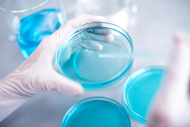 Mani tagliate che eseguono esperimenti su sostanze chimiche in laboratorio