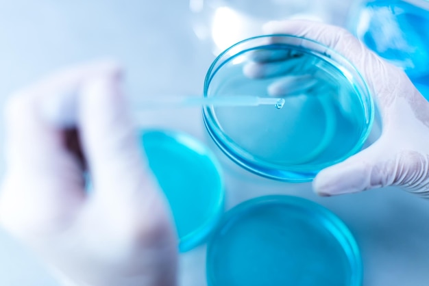 Mani tagliate che eseguono esperimenti su sostanze chimiche in laboratorio
