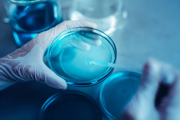 Mani tagliate che eseguono esperimenti su sostanze chimiche in laboratorio