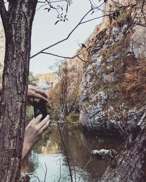 Mani tagliate che fotografano il lago