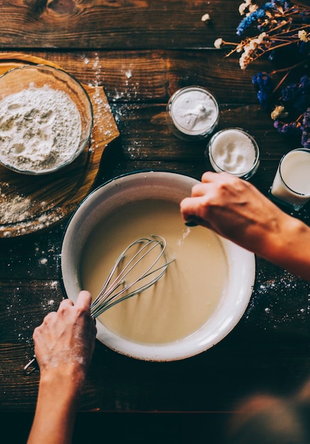 Mani tagliate che preparano il cibo al tavolo in cucina