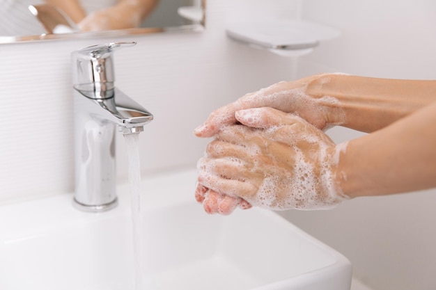 Mani tagliate che si lavano le mani nel lavandino