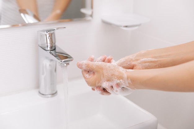 Mani tagliate che si lavano le mani nel lavandino