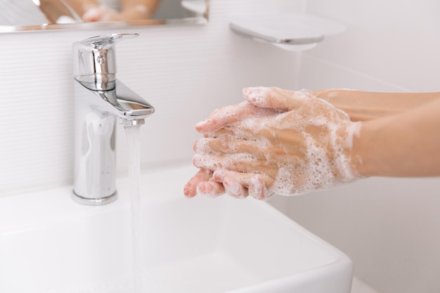 Mani tagliate che si lavano le mani nel lavandino