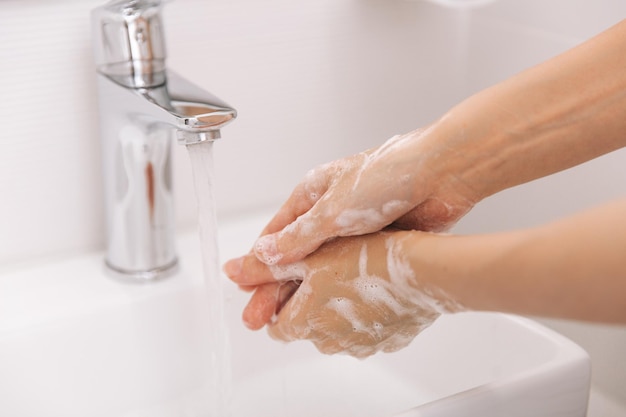 Mani tagliate che si lavano le mani nel lavandino