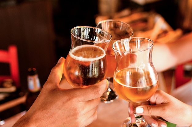 Mani tagliate di persone che brindano a bicchieri di vino