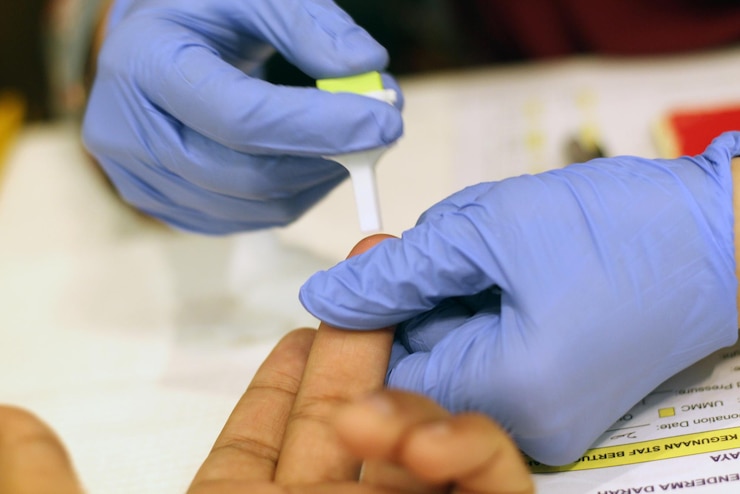 Foto mani tagliate di un medico che rimuove un campione di sangue dal dito di un paziente