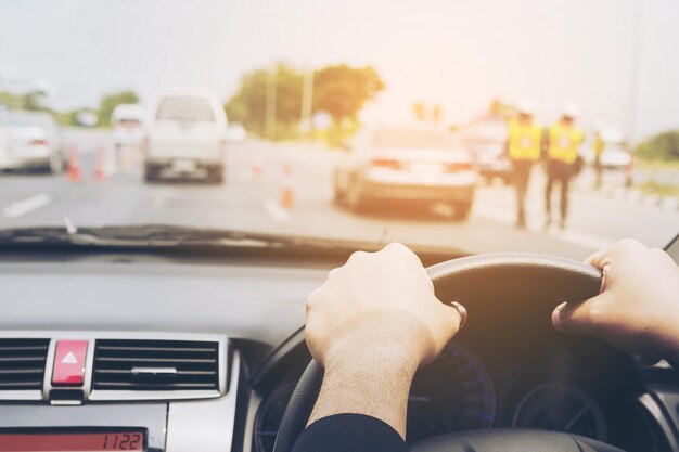 Mani tagliate di un uomo che guida un'auto sulla strada