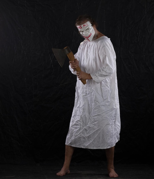 maniaco con una maschera da hockey in abito medico su uno sfondo nero