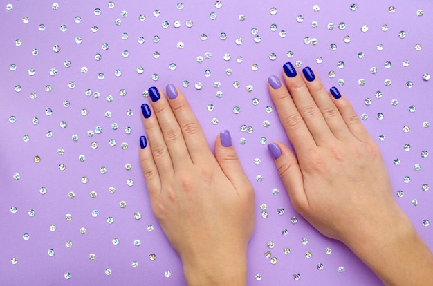 Manicure blu e lilla sulle mani della donna