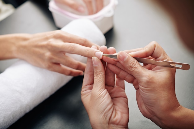 Manicure che pulisce lo sporco da sotto le unghie