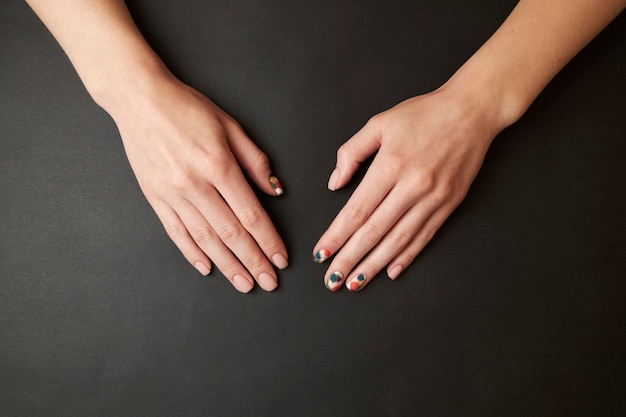 manicure femminile su sfondo nero. chiodo. Le mani delle donne con una manicure su uno sfondo scuro.