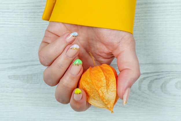 Manicure francese in viola giallo verde su uno sfondo a tinta unita Nail art sulle unghie delle donne Donne