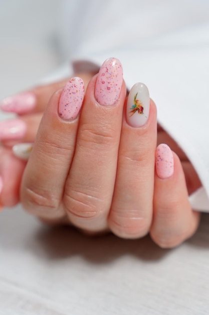 Manicure in primo piano rosa La mano di una donna con una bella manicure rosa