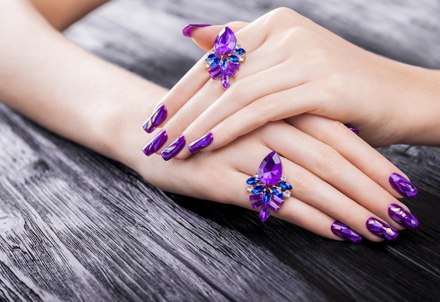 Manicure viola in vetro frantumato su sfondo nero