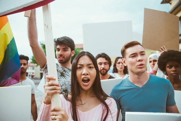 Manifestazione pubblica sulla strada contro problemi sociali e diritti umani. Gruppo di persone multietniche che protestano pubblicamente