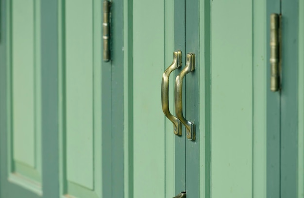 Maniglia della porta d'oro vecchio stile su una porta verde retrò