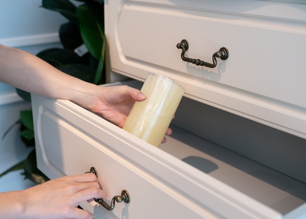 Maniglione aperto in legno bianco. Candela bianca dell&#39;aroma a disposizione.