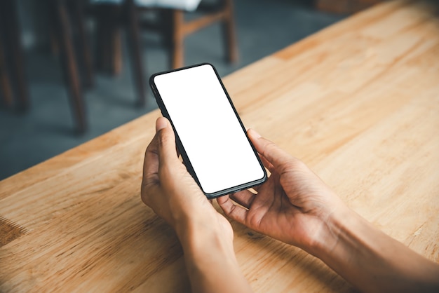 Mano asiatica della donna di affari che utilizza e che tocca lo Smart Phone con lo schermo vuoto in bianco bianco.