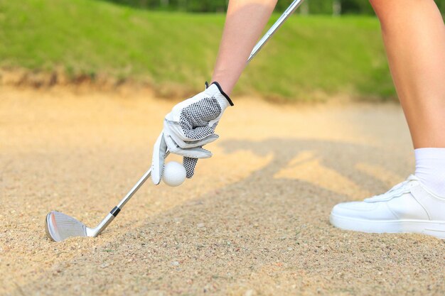 Mano che mette pallina da golf sul tee nel campo da golf.