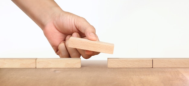 Mano che organizza blocco di legno e successo di crescita del concetto di business