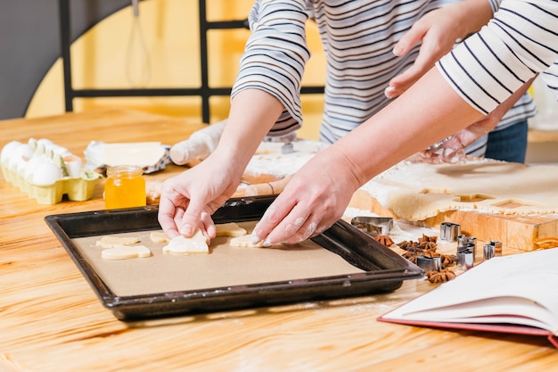 Mano che prepara i biscotti dall'impasto in cucina