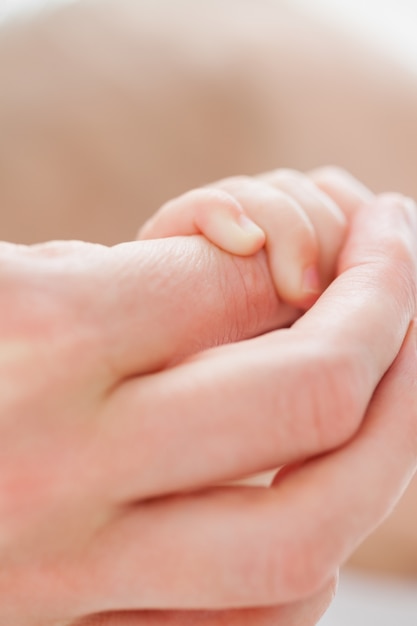 Mano che regge la piccola mano di un bambino