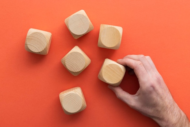 Mano che sceglie un blocco di legno da un concetto di scelta aziendale impostato