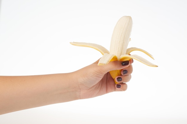 Mano che tiene banana intera isolata su sfondo bianco