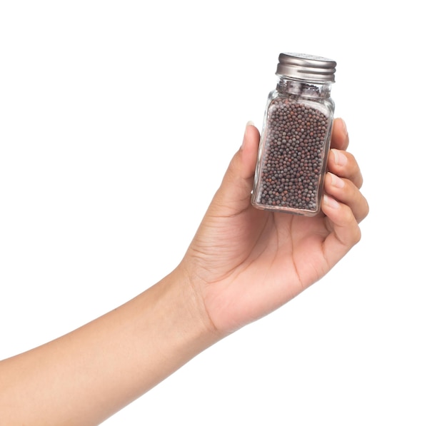 mano che tiene bottiglia di senape nera per condimento isolato su sfondo bianco