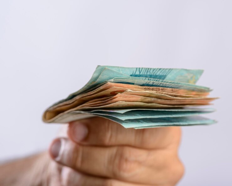 Foto mano che tiene denaro seicento reais valuta brasiliana su sfondo bianco