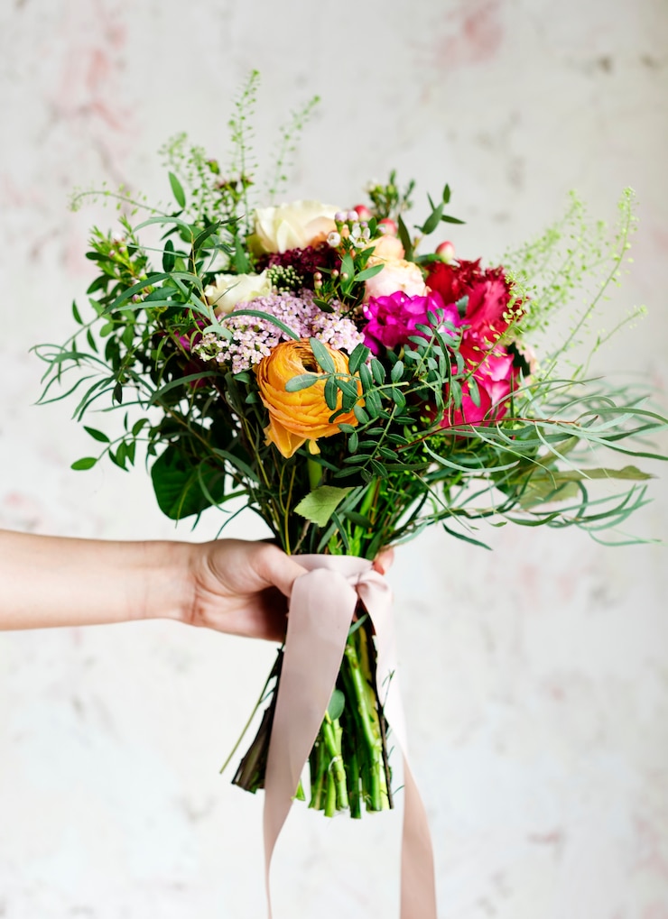 Foto mano che tiene il bel mazzo di fiori