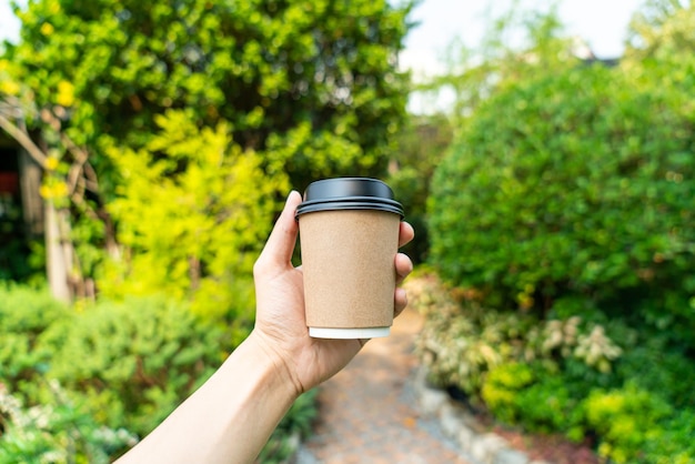 mano che tiene il caffè caldo nel bicchiere da asporto