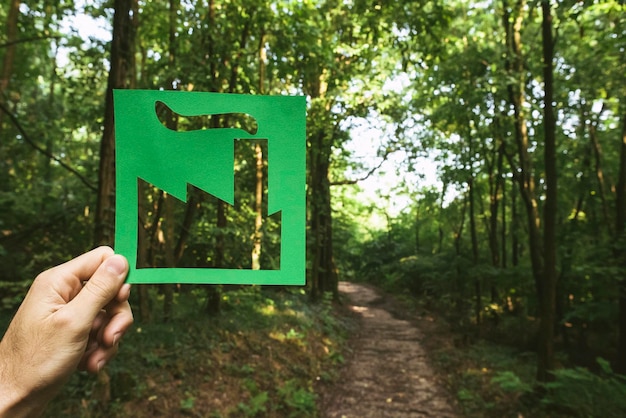 Mano che tiene il simbolo vivente verde ecologico